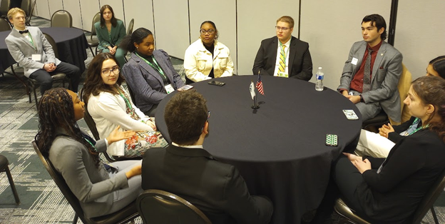 A group of youth sitting around a table. 